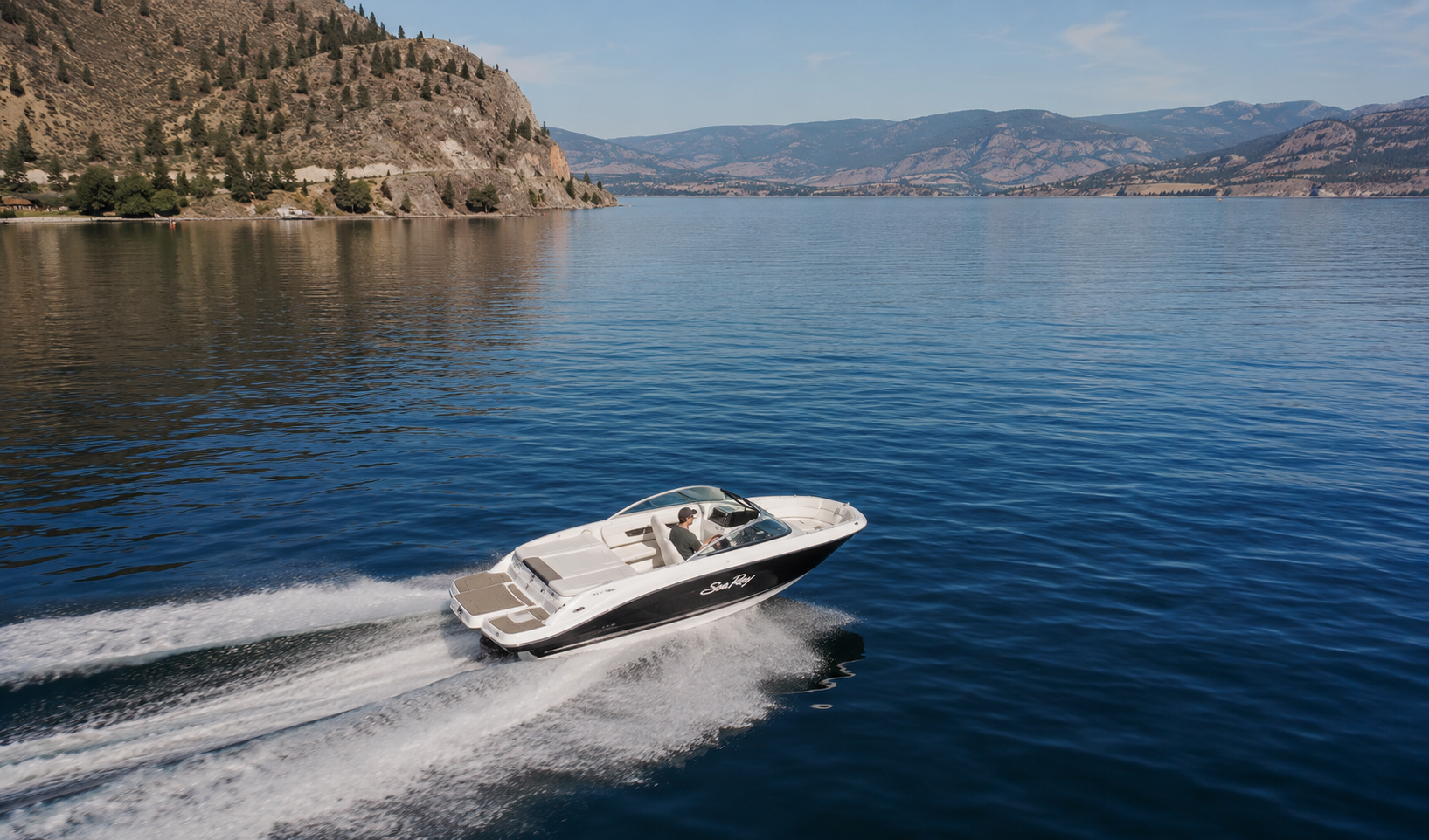 Calm water on Okanagan Lake with the Kelowna shoreline in the distance